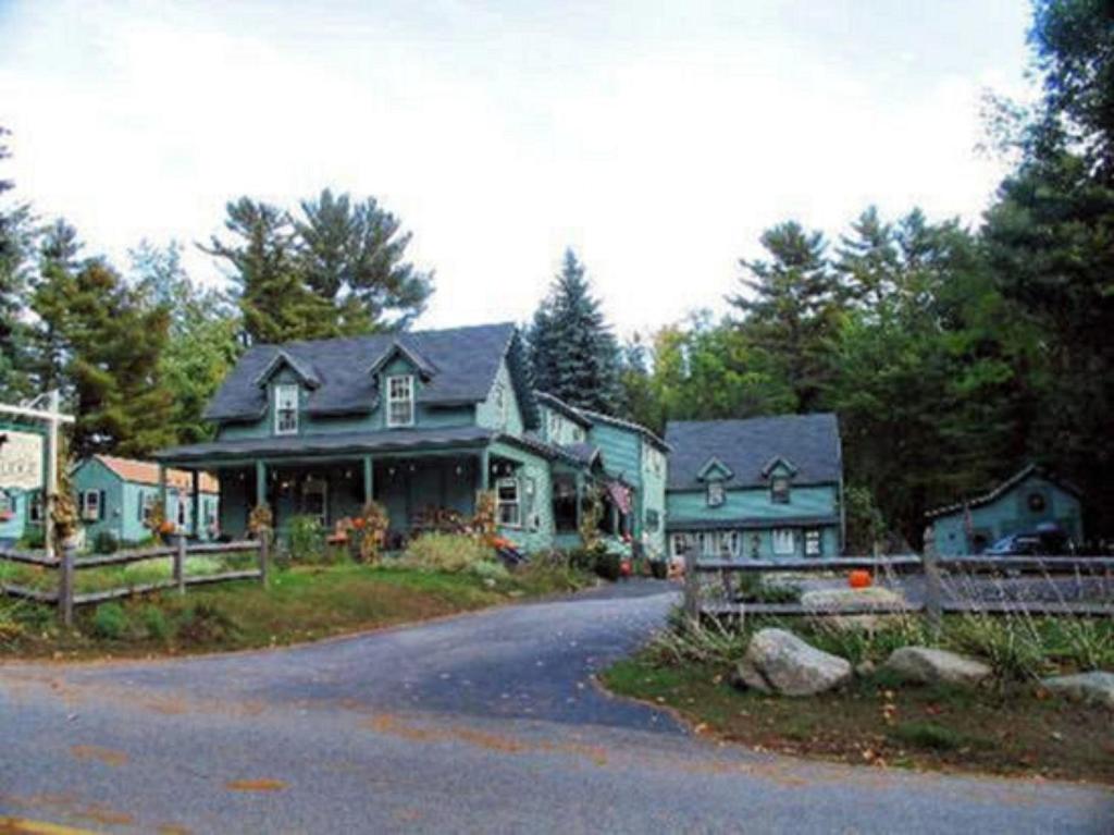 a large house with a fence in front of it at Spruce Moose Lodge in North Conway