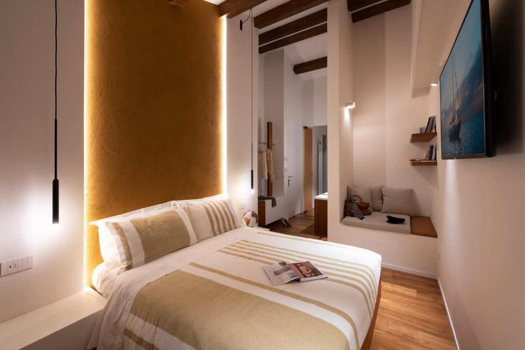 a bedroom with a large bed with a yellow wall at Locanda Remare in Cesenatico