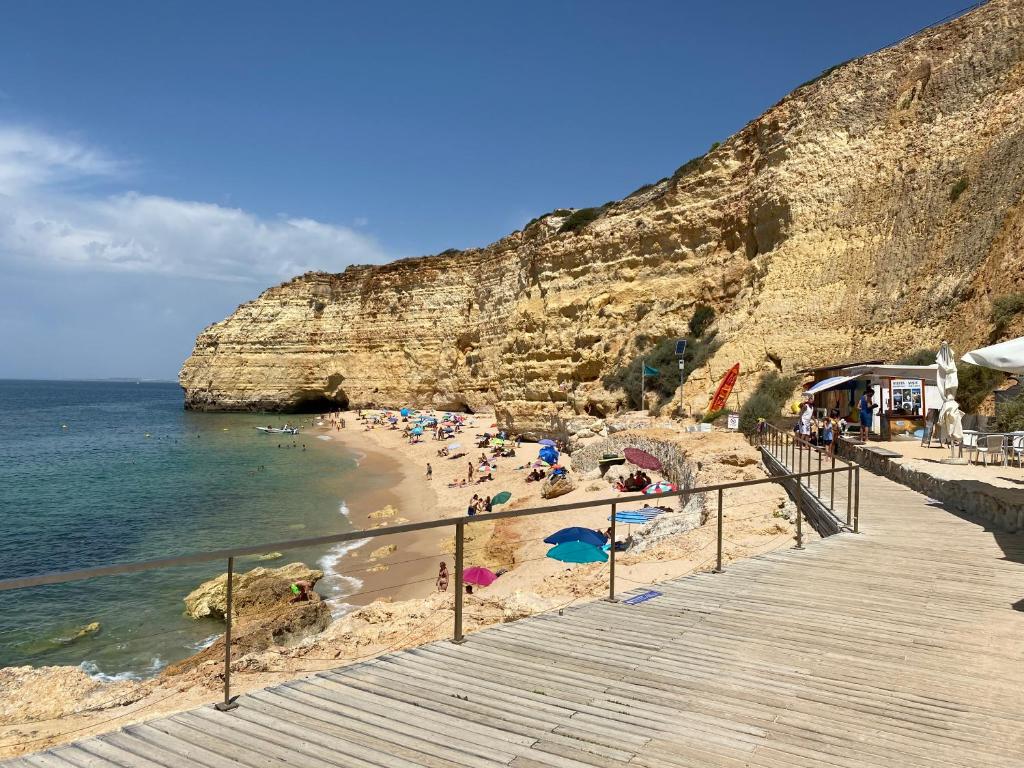 a beach with people on the sand and the ocean at Casa do Milho in Carvoeiro