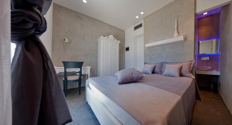 a bedroom with a bed with a desk and a chair at Vigna Caracciolo in Trani