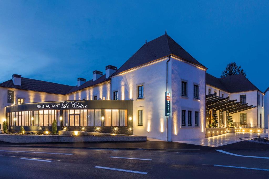 a white building with a sign on the front of it at Hôtel & Spa Les Sept Fontaines Best Western Premier in Tournus