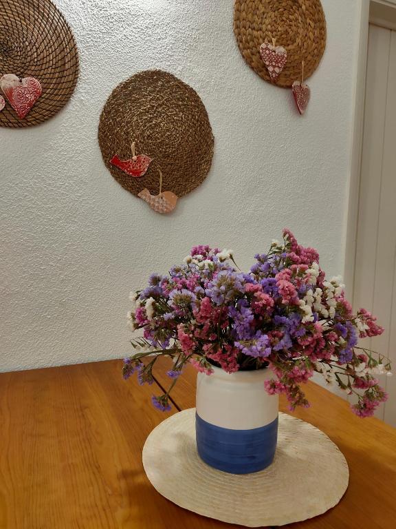 a blue and white vase with flowers on a table at Studio Pedras d'el Rei in Santa Luzia