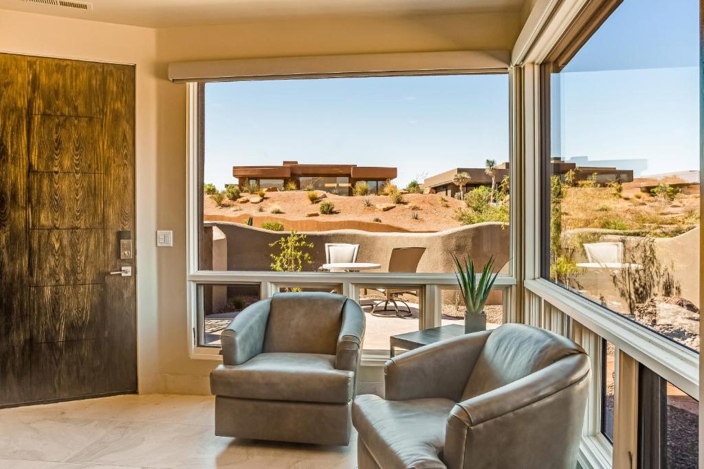 a living room with two chairs and a large window at Entrada Casita with a View in St. George