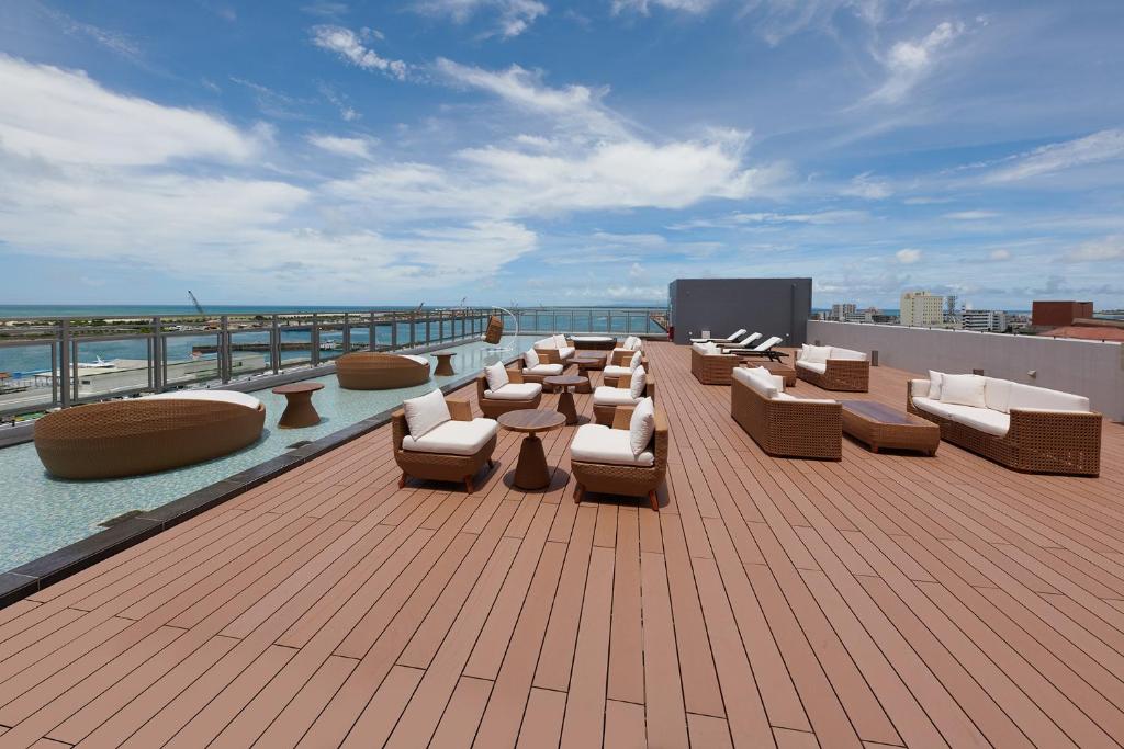 eine Terrasse mit Sofas und Stühlen auf dem Dach in der Unterkunft THIRD ishigakijima in Ishigaki-jima