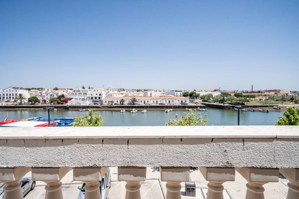 een balkon met uitzicht op een rivier en gebouwen bij Casa Marés in Tavira