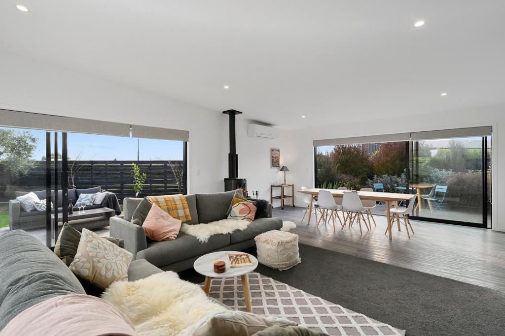 a living room with a couch and a table at Cedar House - Martinborough Holiday Home in Martinborough 