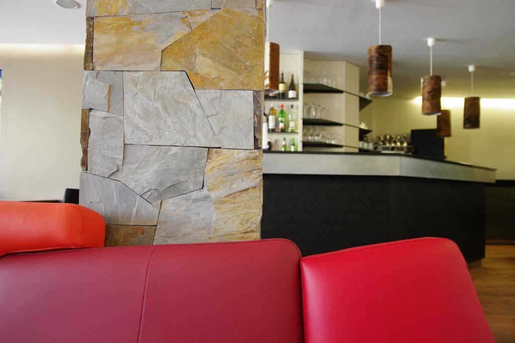 a living room with a red couch and a bar at Le Grand Tétras in Font-Romeu