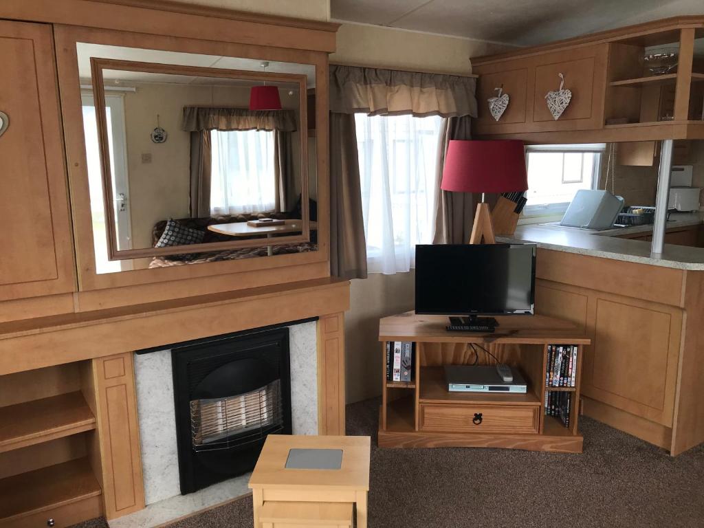 a living room with a fireplace and a television at Golden Sands Ingoldmells (Atlantis) in Skegness