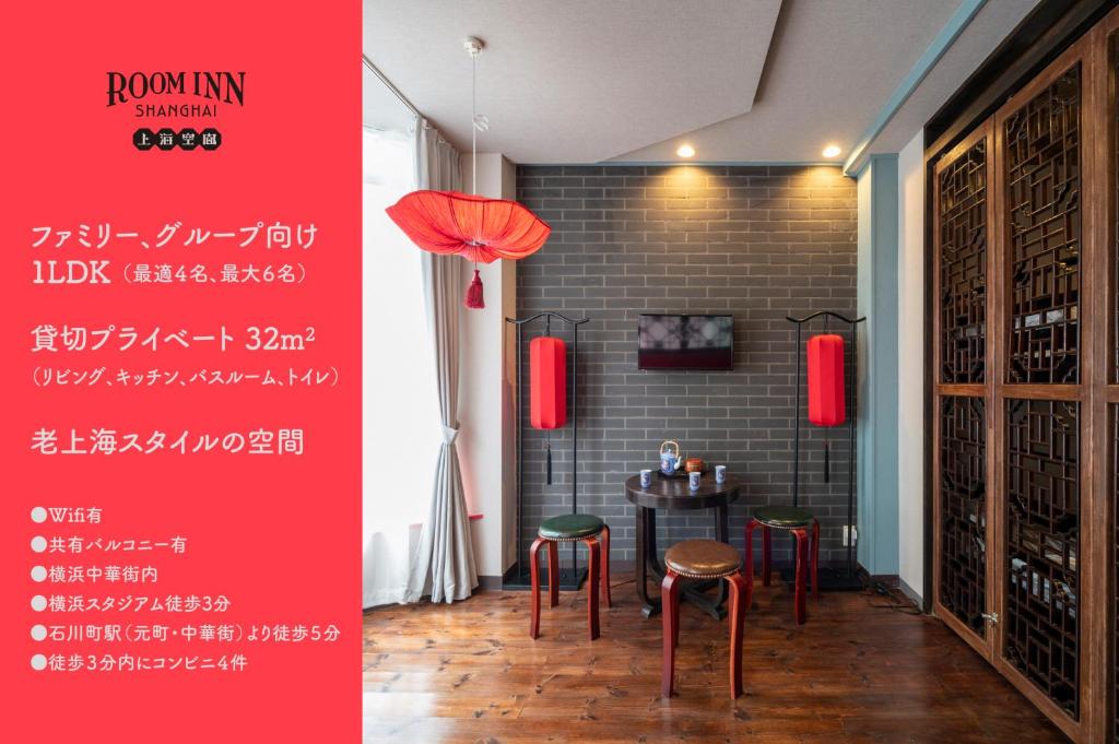 横浜市にあるRoom Inn Shanghai 横浜中華街 Room 2のテーブルと椅子、赤い看板が備わる部屋