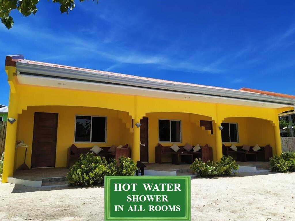 a yellow house with a hot water shower in all rooms at JPH Resort in Malapascua Island