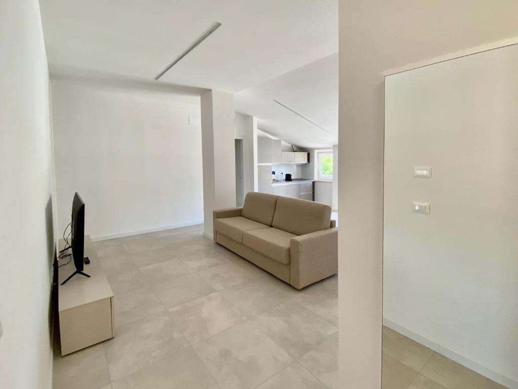 un soggiorno con divano e TV di EM Apartments a Lignano Sabbiadoro