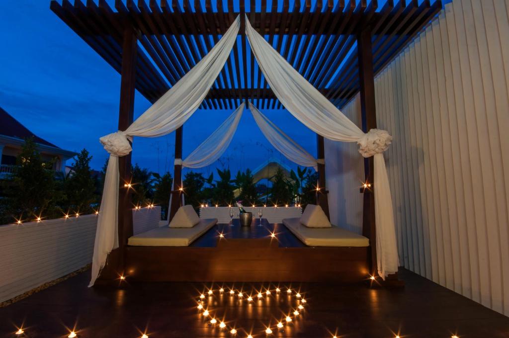 a patio with two beds and a table with lights at Borei Angkor Resort & Spa in Siem Reap