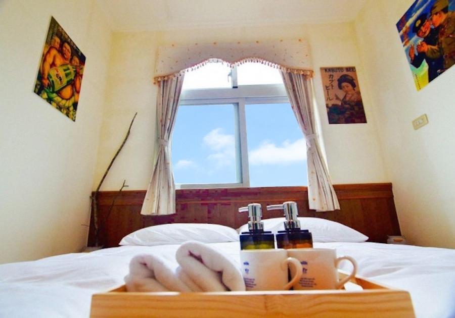 uma bandeja com duas chávenas numa cama com uma janela em Yahu Hotel em Fenqihu