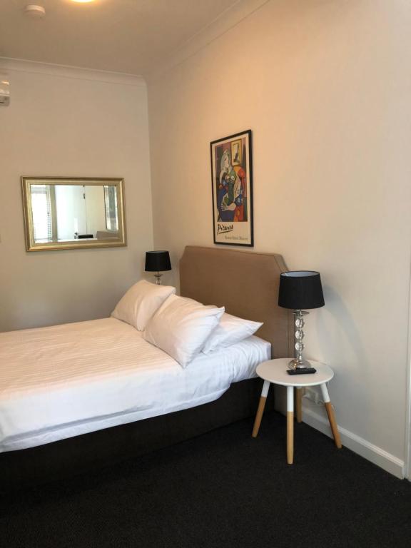 Un dormitorio con una cama y una mesa pequeña. en Hotel 59 Sydney, en Sídney