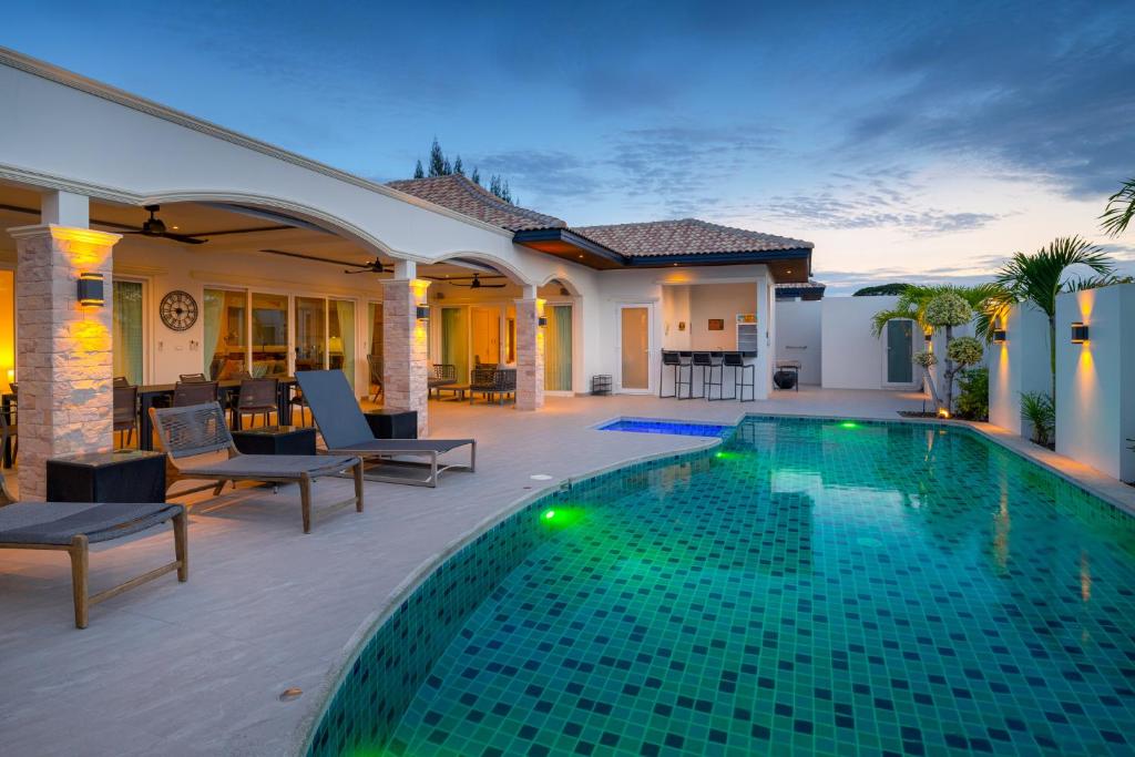 een villa met een zwembad en een huis bij Orchid Paradise Homes 515 in Hua Hin