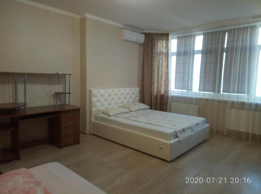 een slaapkamer met een bed, een bureau en een raam bij Люкс апартаменты на Позняках in Kiev