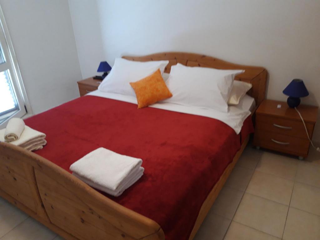 a bedroom with a large wooden bed with white pillows at Sasa Apartments Kastel Stafilic Croatia in Kaštela