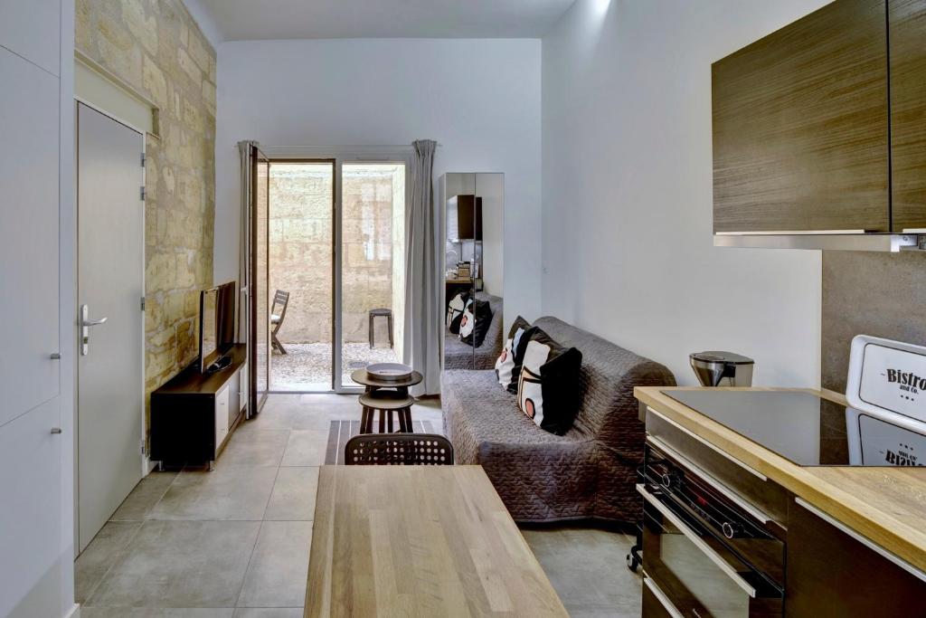 un salon avec un canapé et une table dans l'établissement Le Well Done - Joli T2 avec terrasse, à Bordeaux