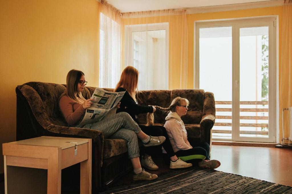 a group of people sitting on a couch in a living room at Kallaste Hostel in Kallaste