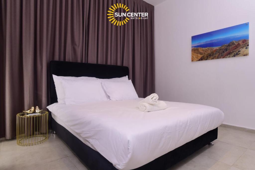 a bedroom with a large bed with white sheets at Sun Center Eilat in Eilat
