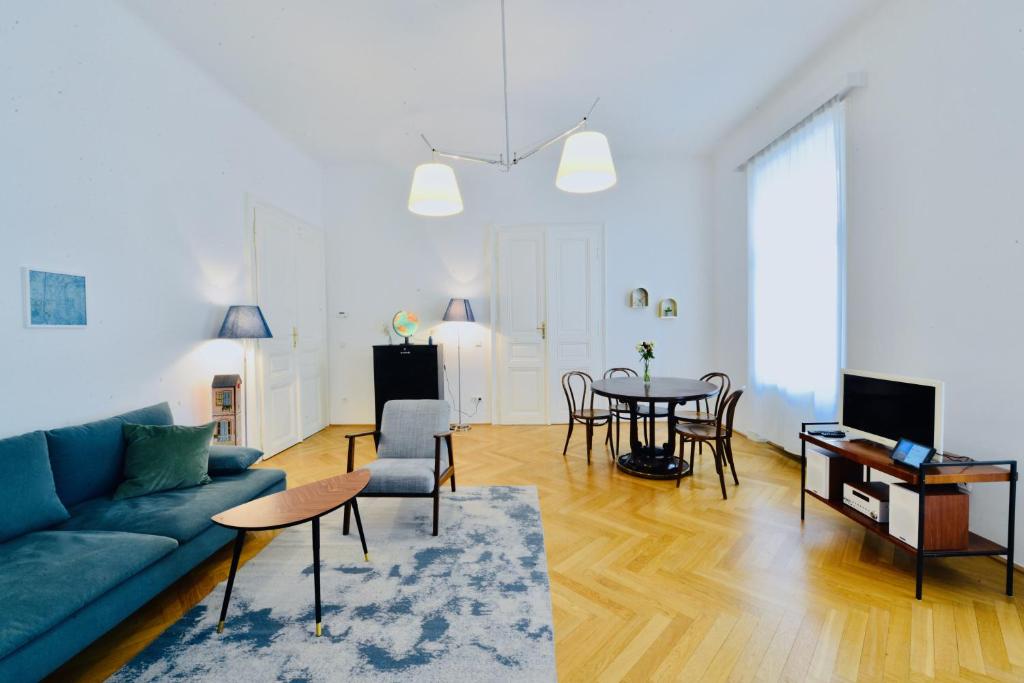 ein Wohnzimmer mit einem blauen Sofa und einem Tisch in der Unterkunft Apartment Wien in Wien