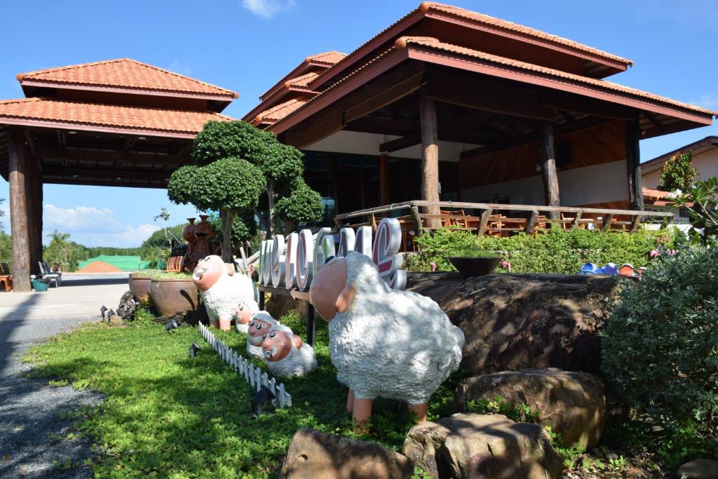 a group of figurines of chickens standing in the grass at Palmsuay Resort in Ban Dong Klang