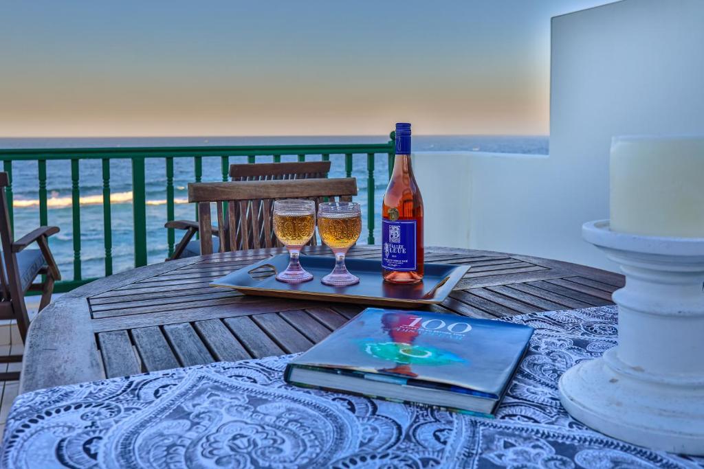 巴利托的住宿－15 Skiathos-Spacious Family Beachfront apartment，一张桌子,上面放着两杯酒和一瓶葡萄酒