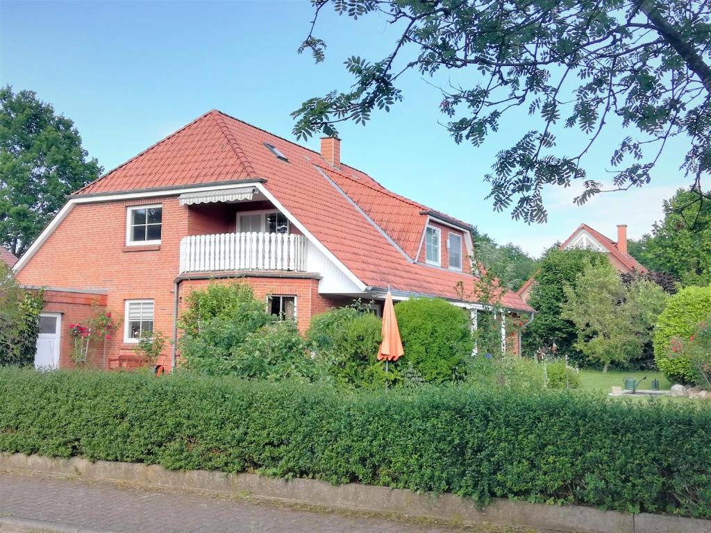 a house with a red roof and a balcony at Ferienwohnung Gisela Rohde in Bad Bramstedt