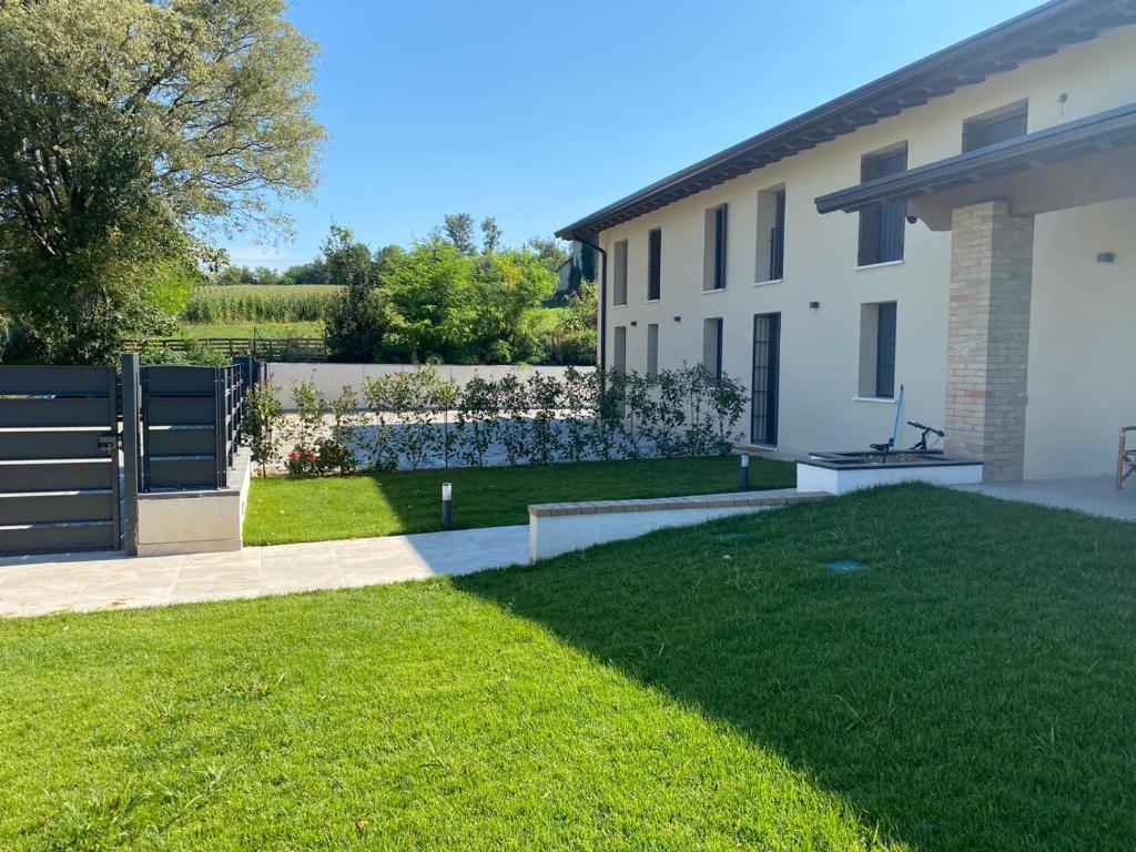 a backyard of a house with a green lawn at b&b Bike Home - in Castiglione delle Stiviere