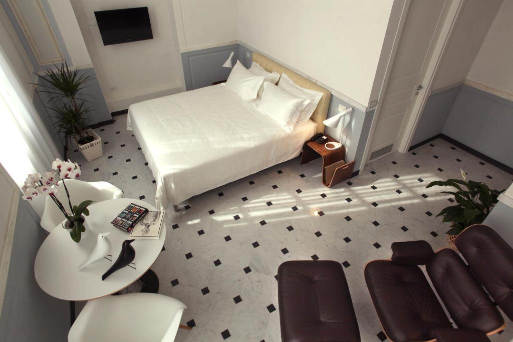 
a room with two beds, a toilet and a rug at Hotel Le Nuvole Residenza d'Epoca in Genoa
