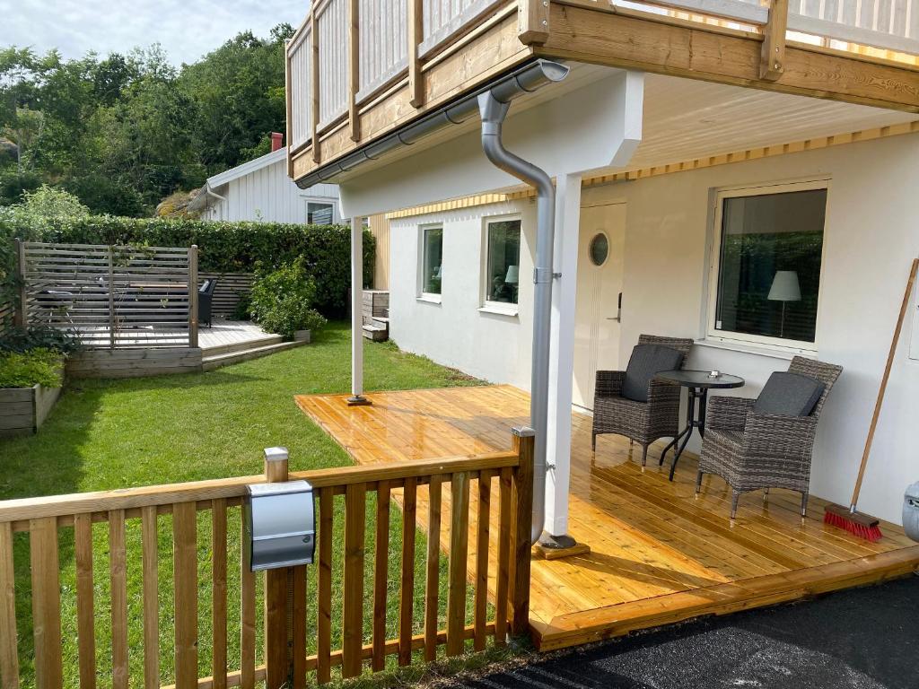 eine Holzterrasse mit Stühlen und einem Tisch auf einem Haus in der Unterkunft Monekil 8 in Hamburgsund