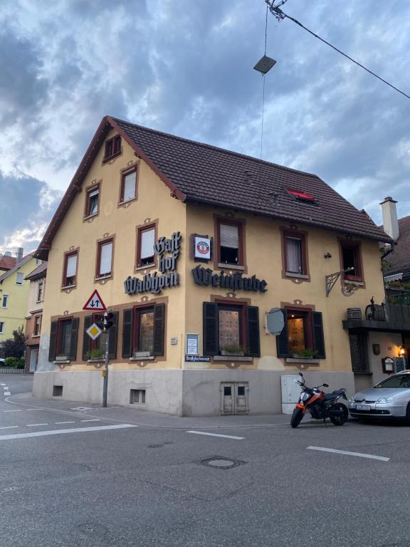 ein Gebäude mit einem Motorrad, das davor geparkt ist in der Unterkunft Hotel Waldhorn in Stuttgart