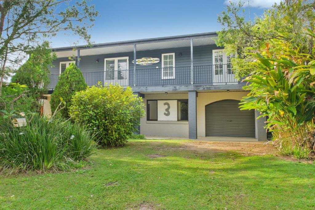 a house with a garage in front of it at Bonny Beach House in Bonny Hills