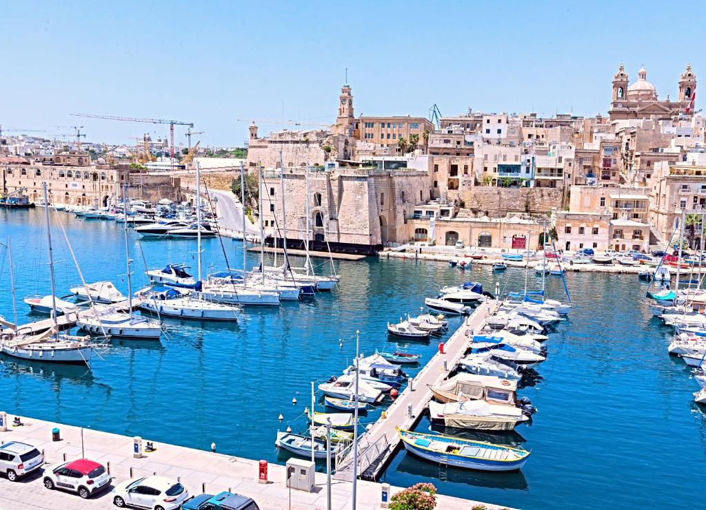 un grupo de barcos atracados en un puerto con edificios en Vittoriosa' Seafront 2 Bed Highly Furnished Apartment, en Birgu
