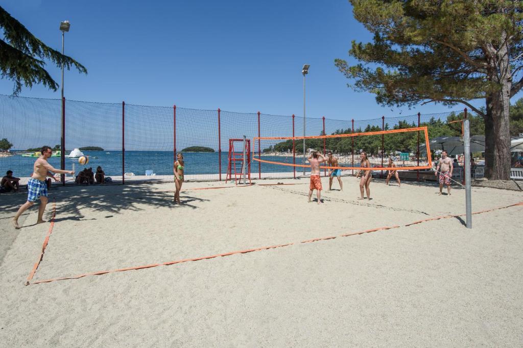 a group of people playing volleyball on the beach at Maistra Camping Valkanela Mobile homes in Funtana