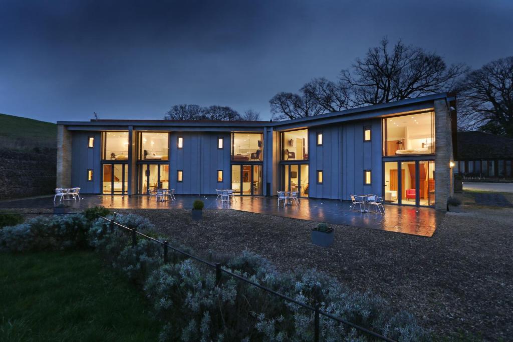 une grande maison avec des portes en verre et des fenêtres la nuit dans l'établissement The Farmyard Adults Only, à Yeovil