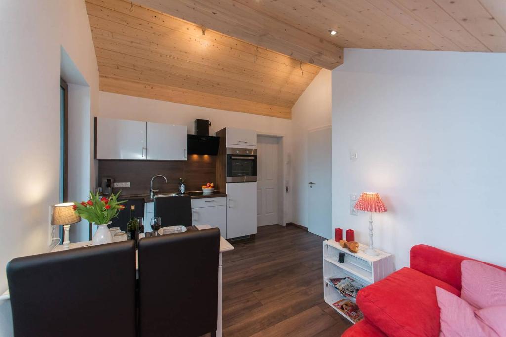 een woonkamer met een rode bank en een keuken bij Ferienwohnung Kayserlay in Hürtgenwald