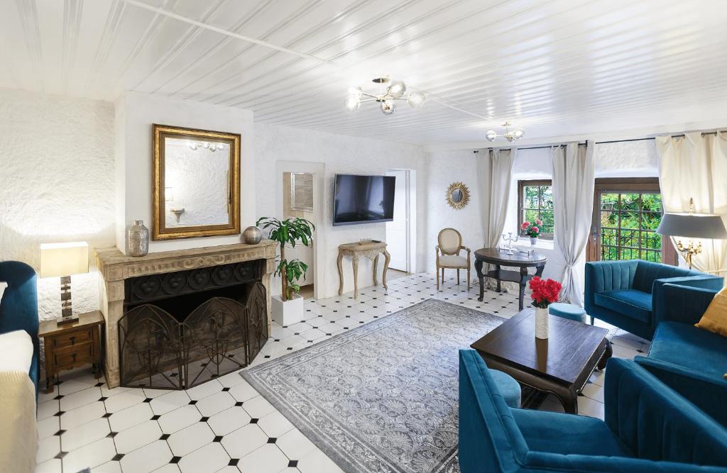 uma sala de estar com lareira e cadeiras azuis em Château du Châtelard | 2 persons em Montreux