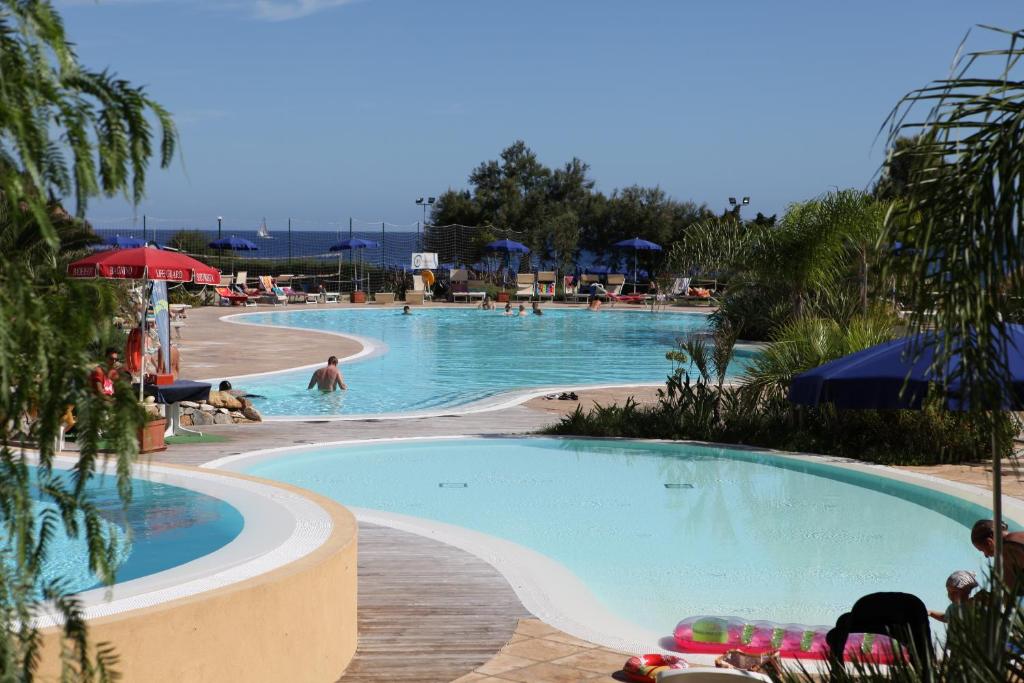 una piscina en un complejo con gente nadando en él en TH Ortano - Ortano Mare Residence, en Rio Marina