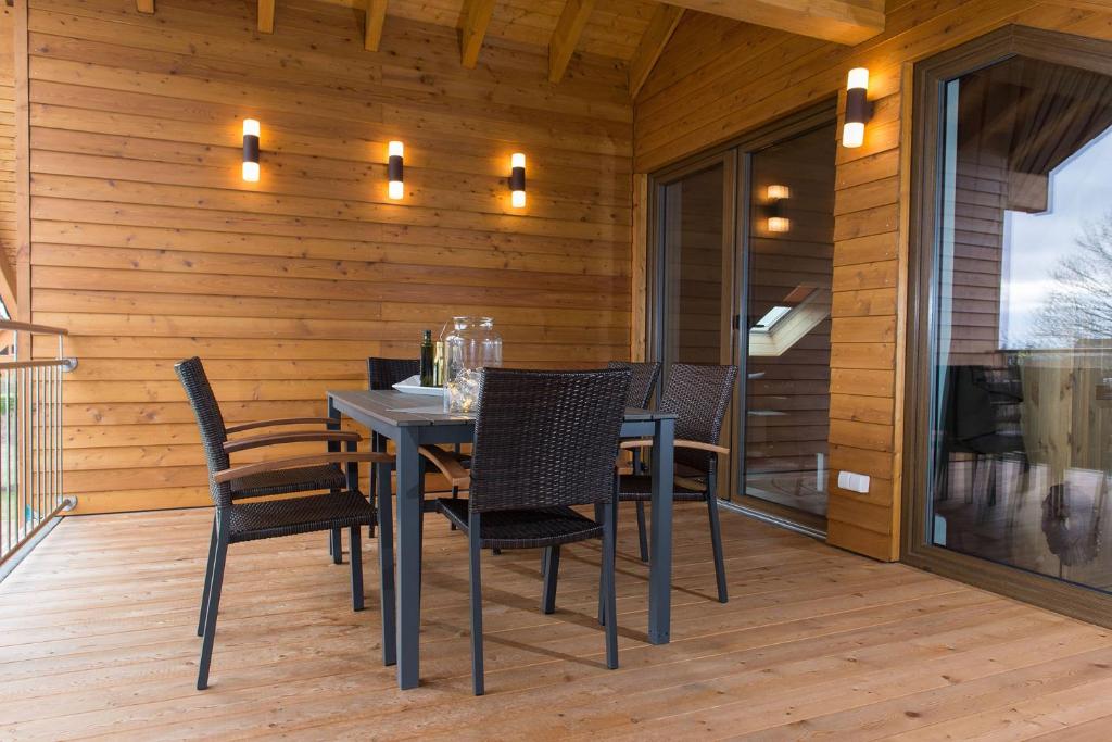 a dining room with a table and chairs on a deck at Schöne moderne Ferienwohnung-Balkon-Fahrradparkplatz-Wallbox in Hürtgenwald