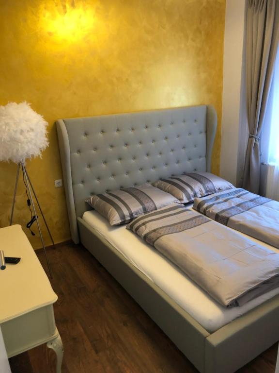 ein großes Bett in einem Zimmer mit gelber Wand in der Unterkunft Wohlfühlen in der Altstadt von Steyr in Steyr