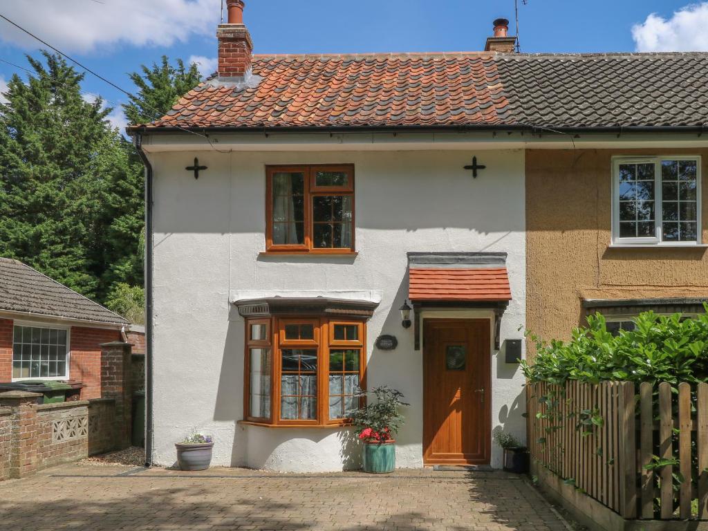 a white house with a orange door at Willow Cottage in Watton