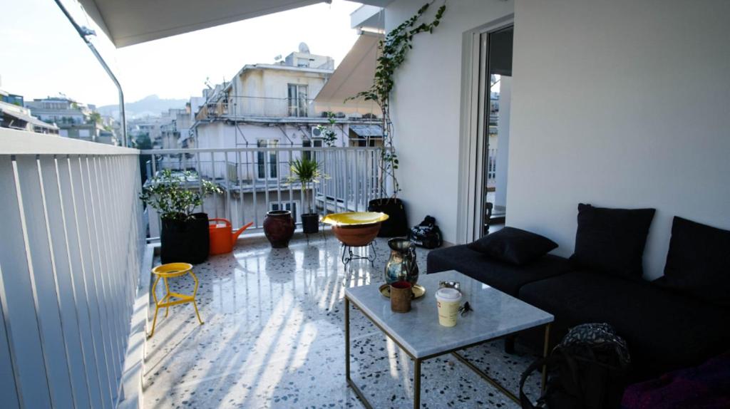 a living room with a couch and a table on a balcony at Heart of Athens!! central nice rooftop flat in Athens