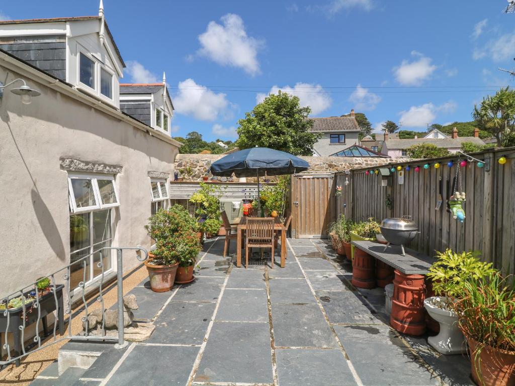 a patio with a table and an umbrella at Ebenezer Cottage in Marazion