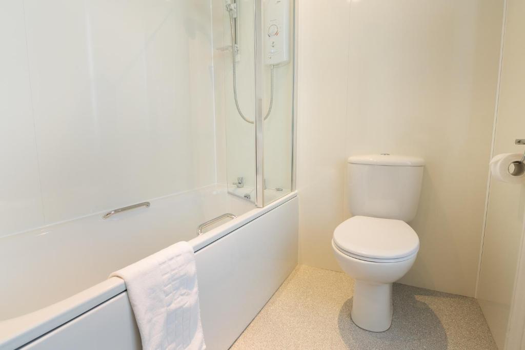 a white bathroom with a toilet and a shower at Laichmoray Hotel in Elgin