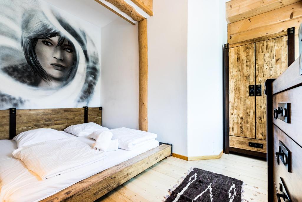 a bedroom with a bed with a painting on the wall at Apartament Harnasiowa Grota in Kościelisko