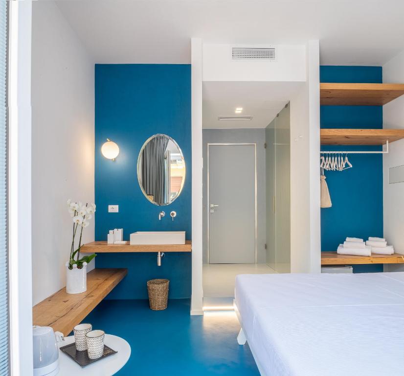 a bedroom with blue walls and a bed and a mirror at Near Ortigia in Siracusa