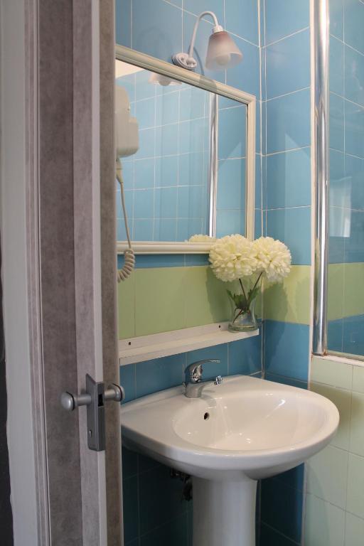 La salle de bains est pourvue d'un lavabo et d'un miroir. dans l'établissement VesuView Guest House near the Ruins, à Pompéi
