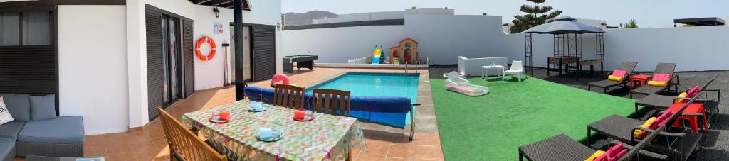 a backyard with a pool and a play yard at VILLA CARLA FUN FAMILY in Playa Blanca