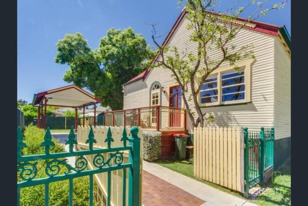 a green fence in front of a house at Bright 3-bedroom apartment - Central Armidale in Armidale